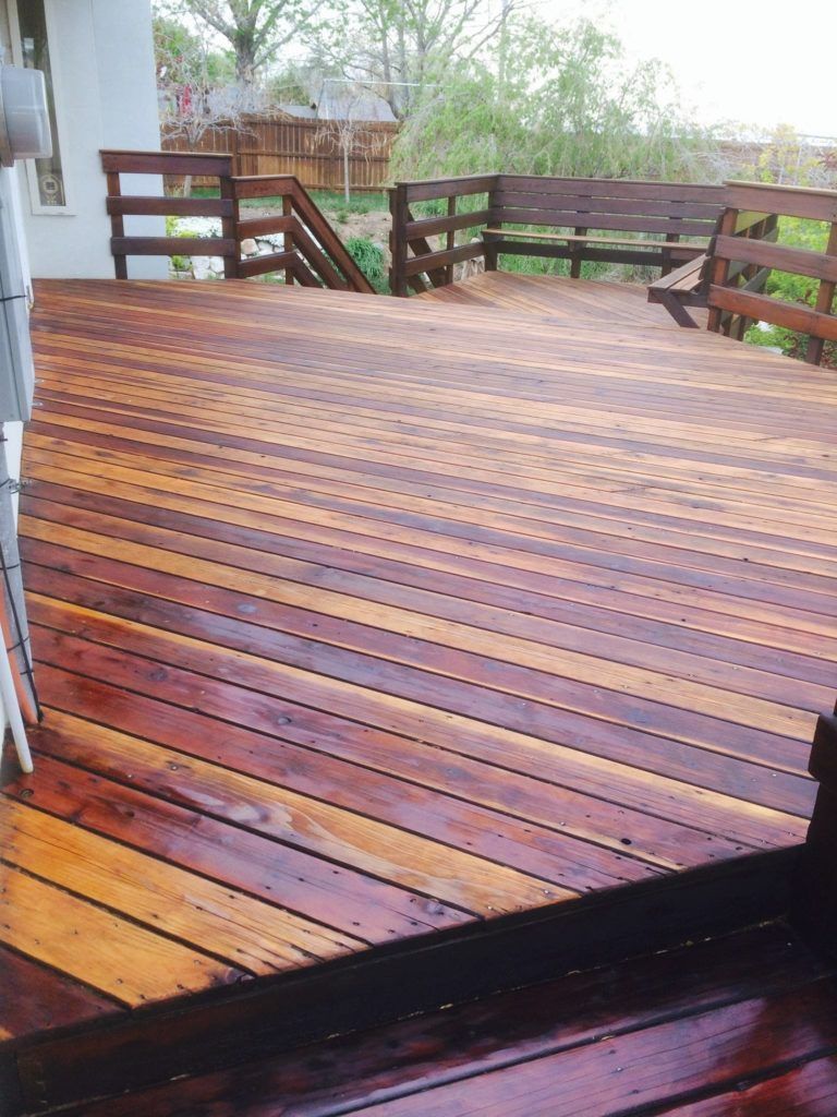 a wooden deck with stairs and a bench on it