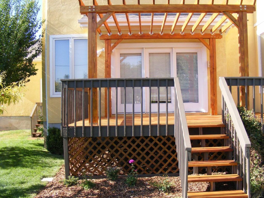 a yellow house with a wooden deck and stairs
