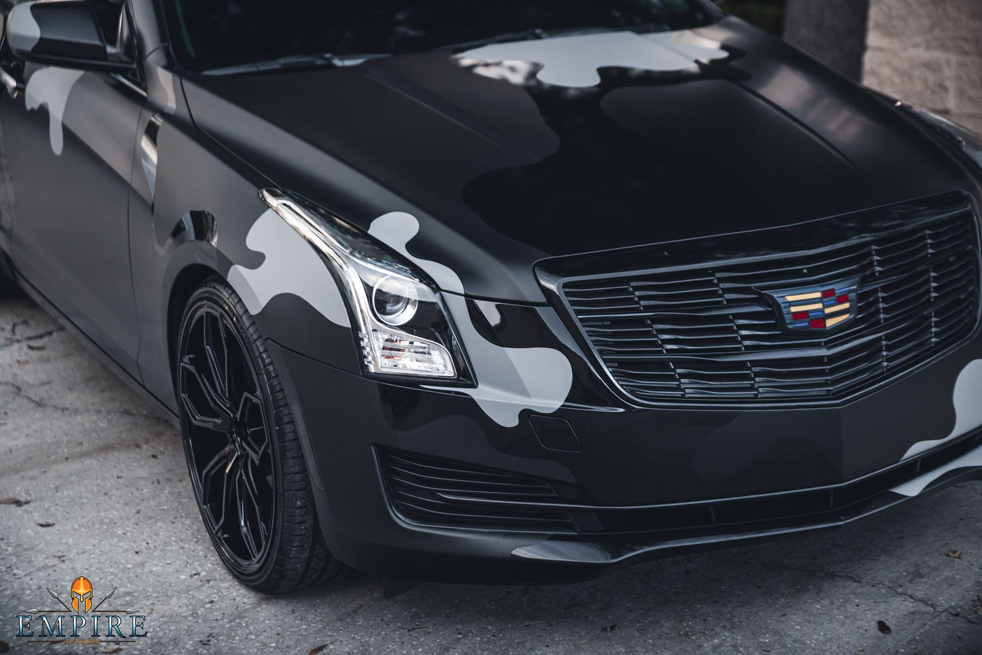 A black cadillac with a camouflage paint job