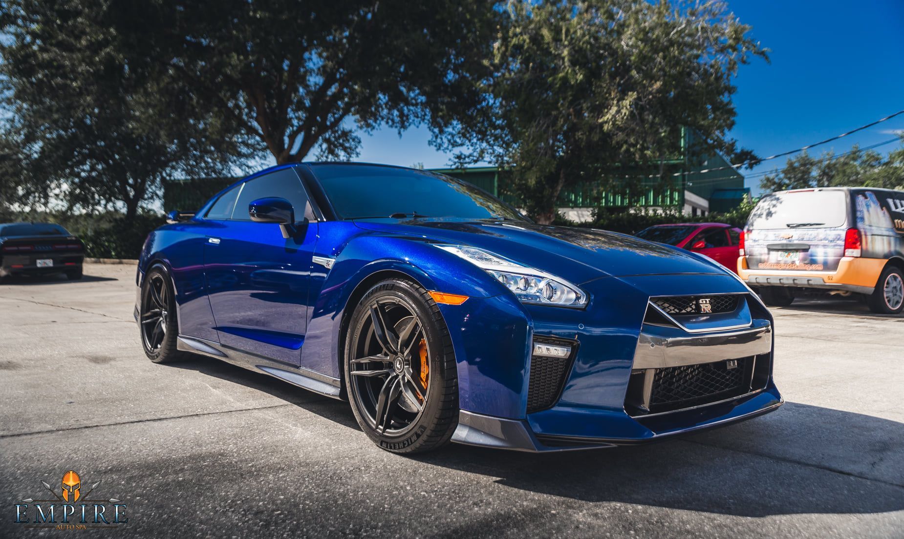 A blue sports car is parked in a parking lot.