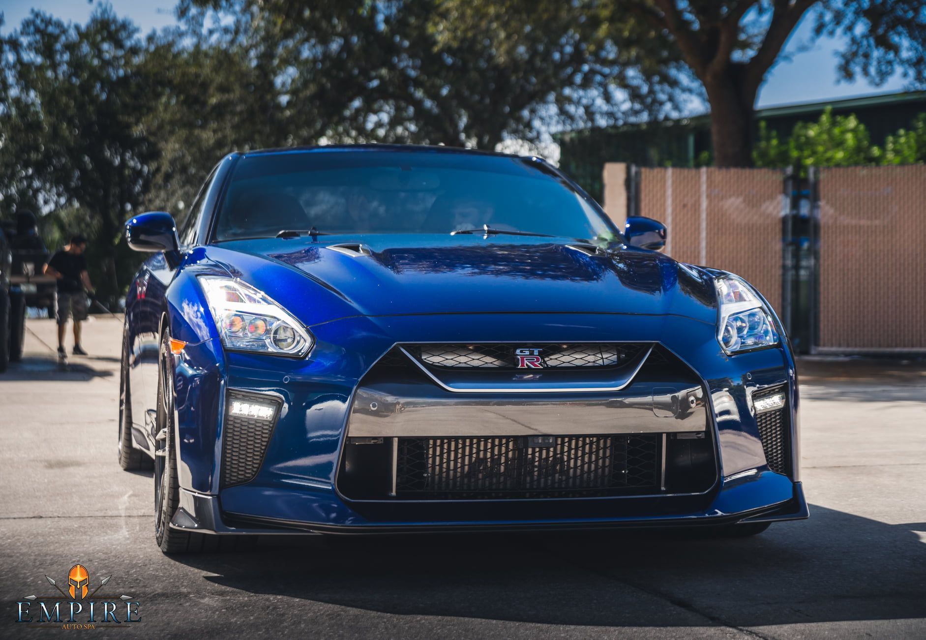 A blue nissan gtr is parked on the side of the road.