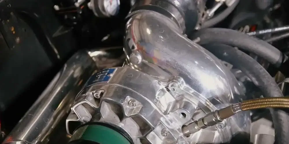 A close up of a turbocharger on a car engine.