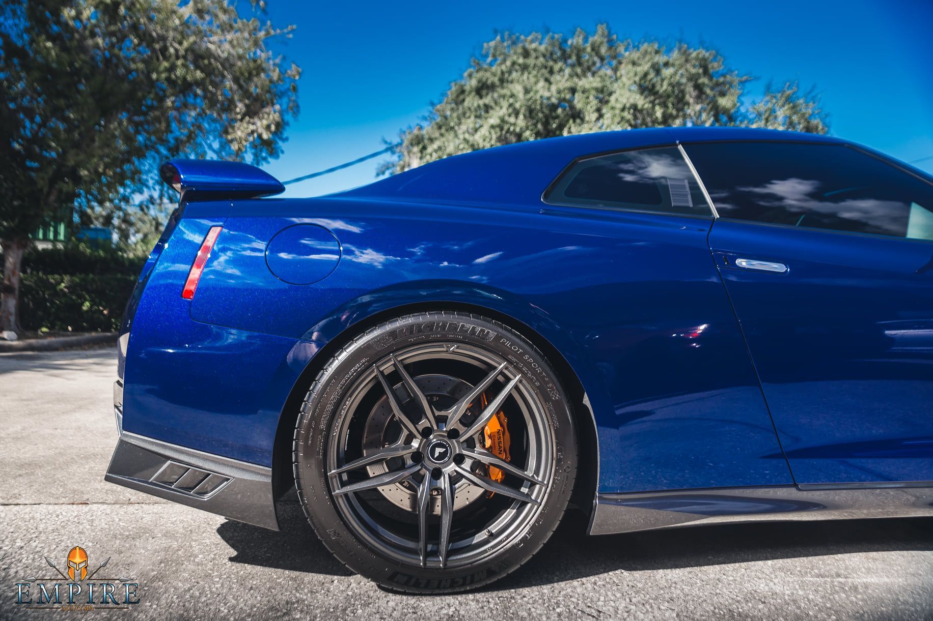 A blue sports car is parked on the side of the road.
