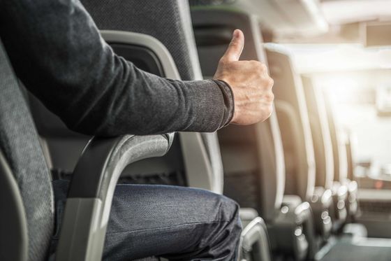 Person seated on a bus giving a thumbs-up gesture. Person seated on a bus giving a thumbs-up gesture.