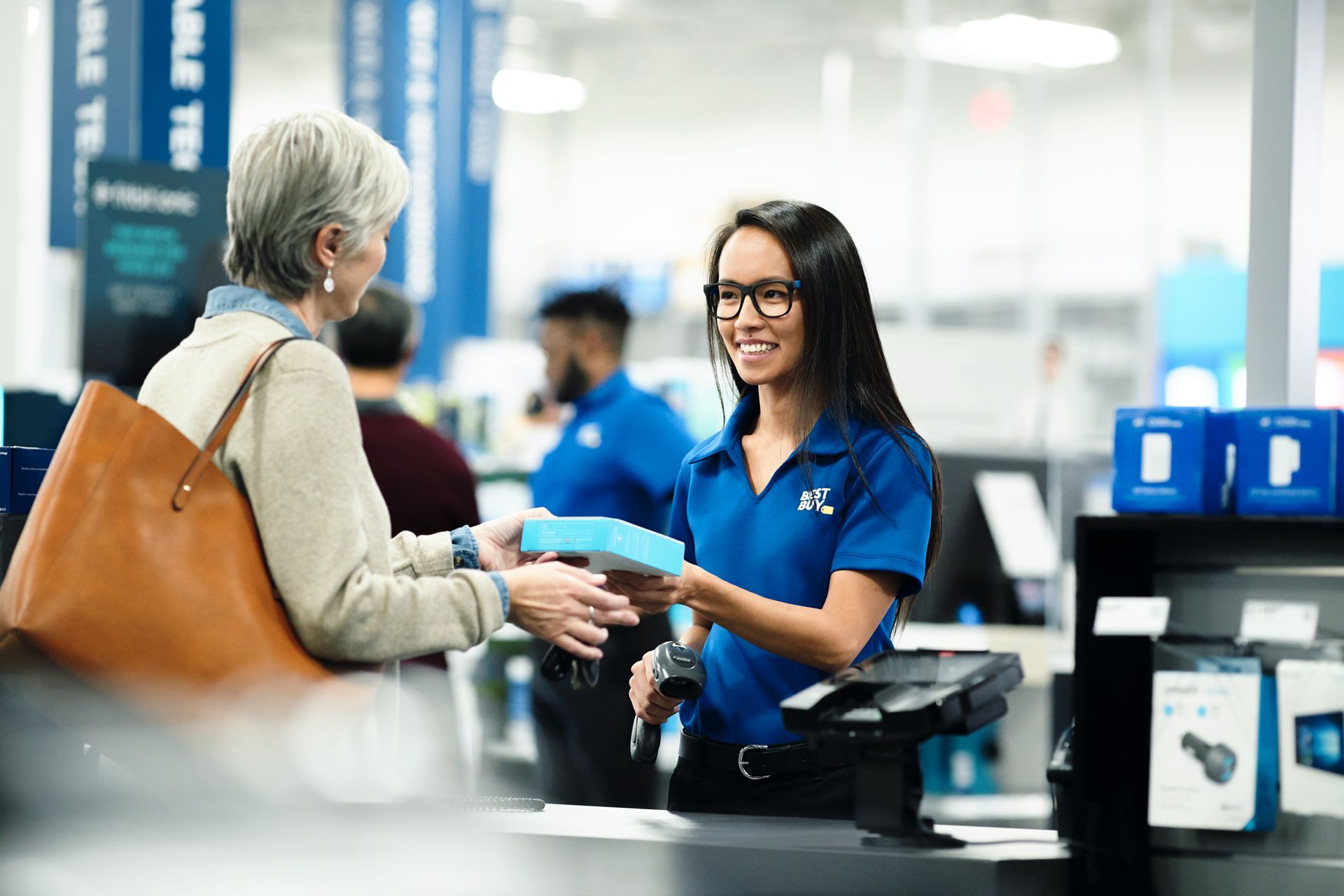 A woman is giving a gift to an older woman in a store.