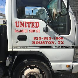 White United Roadside Service tow truck cab with red lettering and Houston phone number on the door