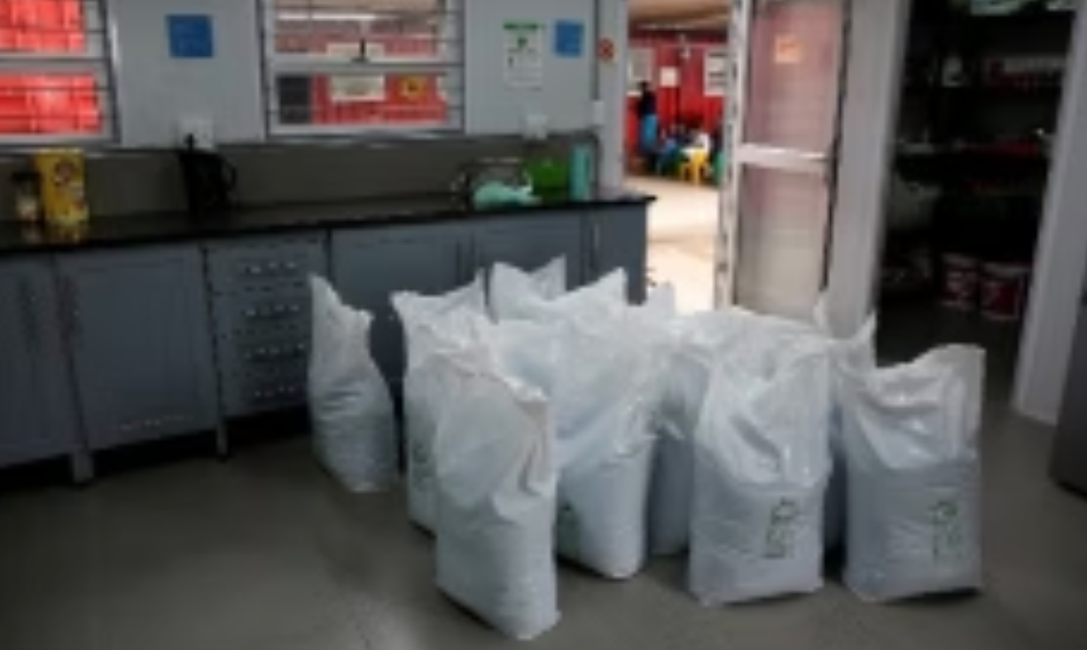 Bags of white material inside a room with a counter and open doorway.