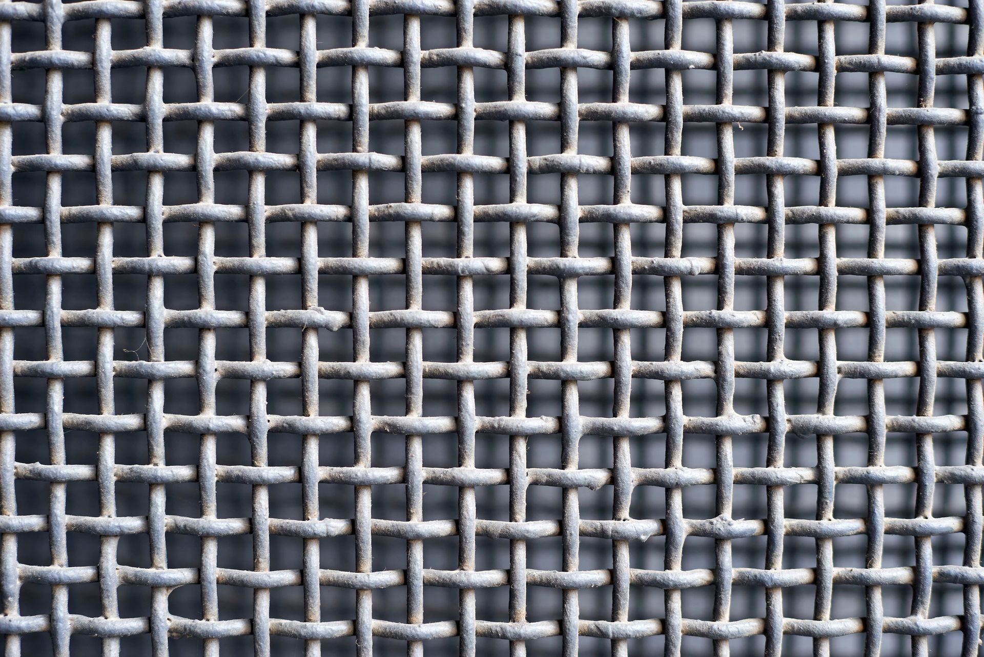Woven wire cloth supplier displaying an interwoven metal wires forming a grid pattern. Woven wire cloth supplier displaying an interwoven metal wires forming a grid pattern.