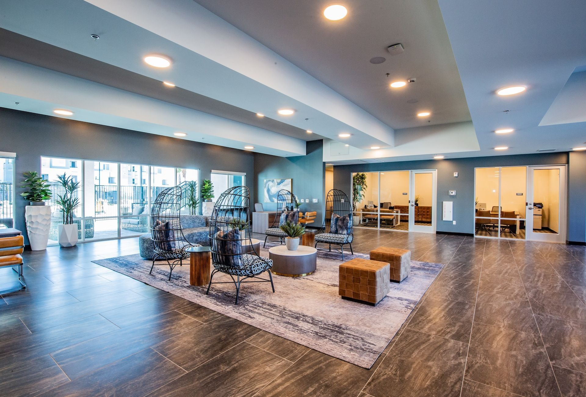 Modern lobby with seating area, large rug, and glass windows.