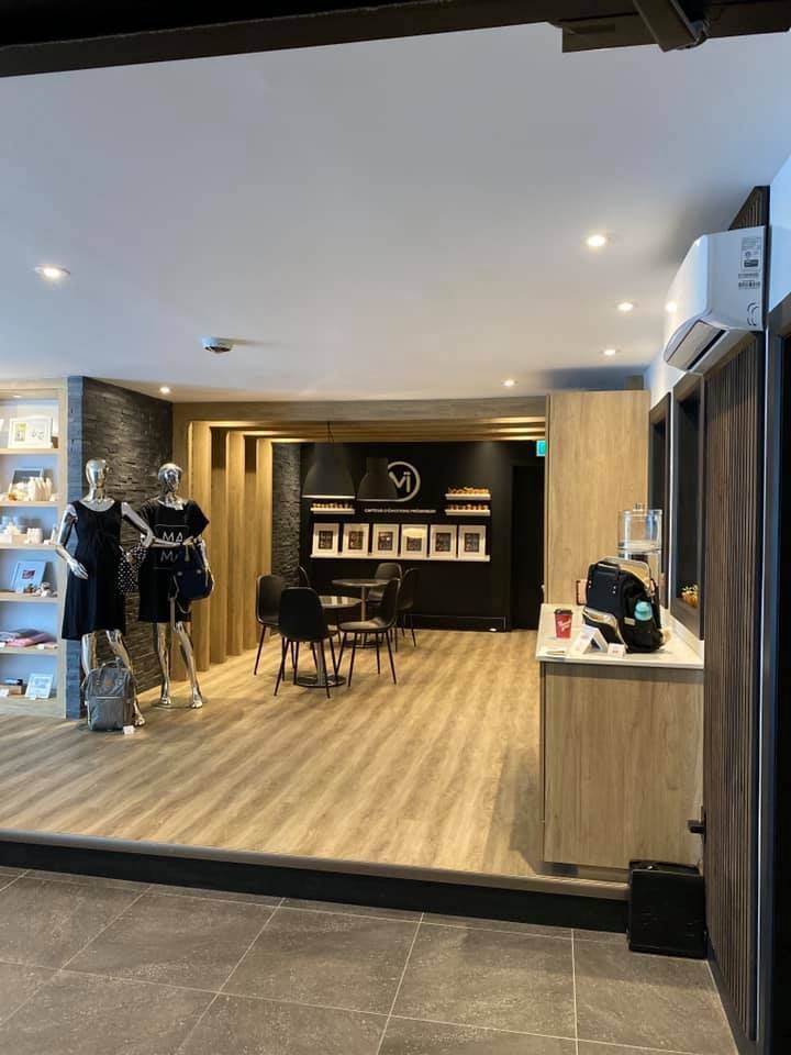 Interior of a shop with mannequins, seating, and products on display.