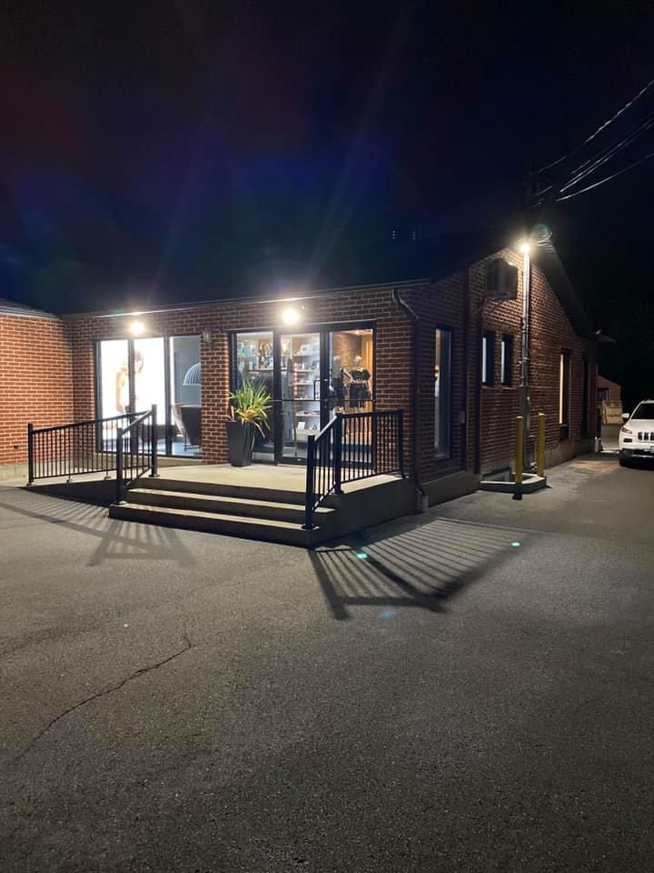 Brick building at night with lit windows, entrance with steps, and street lights.