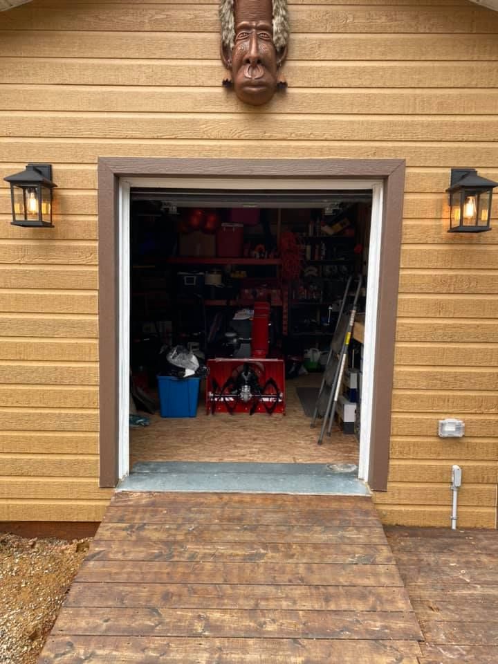 Garage with open door, wooden ramp, and decorative face above the opening.