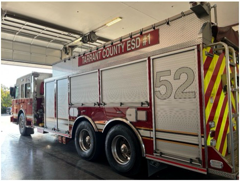 A red and white  fire truck with the number 52 on the side is parked in a fire station.