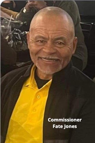 Smiling man wearing yellow shirt and black jacket. Text: 