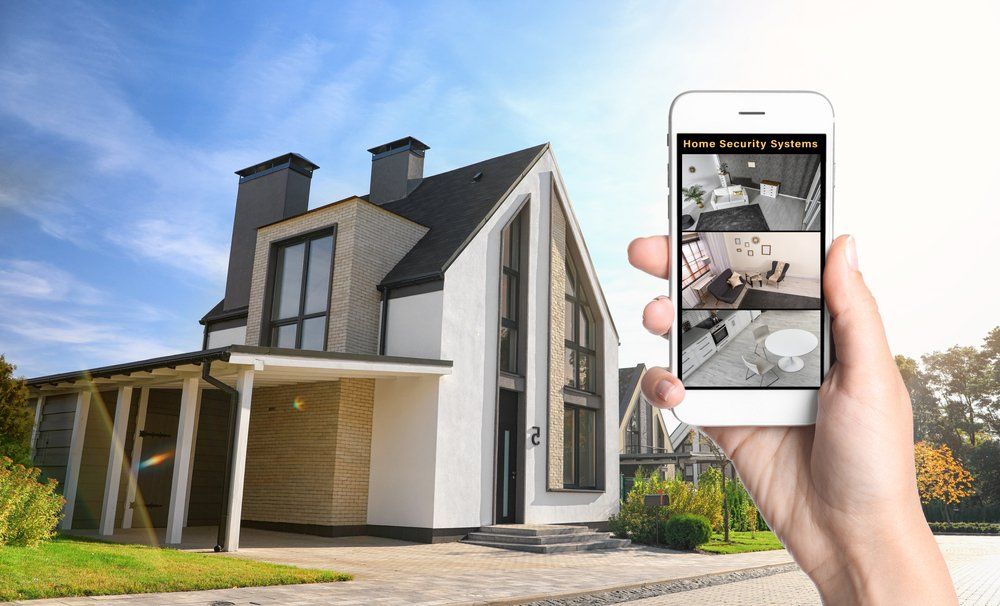 Une personne tient un téléphone portable devant une maison.