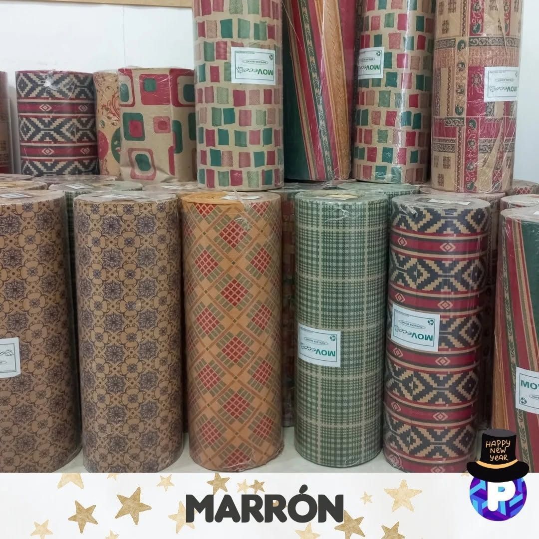 Montones de rollos decorativos tejidos con estampados rojos, verdes y marrones expuestos en una tienda.