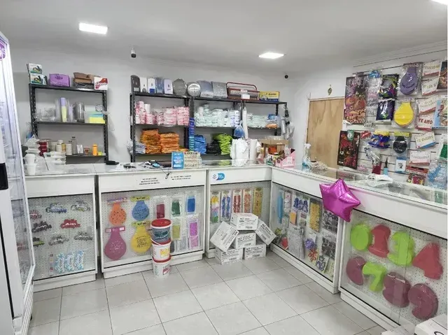 Luminoso interior de tienda con estanterías, vitrinas de cristal y coloridos artículos para el hogar.