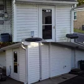 Before soft washing a dirty 1-story house in Belleville, IL. SprytNa Exterior removing heavy organic growth from siding.