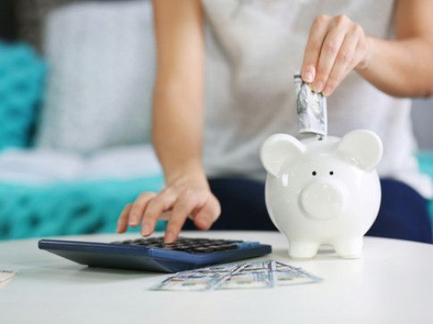 woman pitting money on her peggy bank