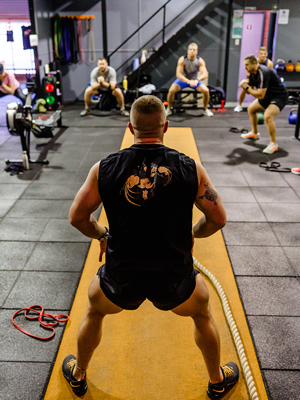 a gym trainer leading the way in a group training session
