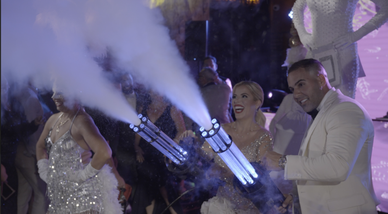 Bride and groom celebrating with sparklers at a nighttime wedding reception
