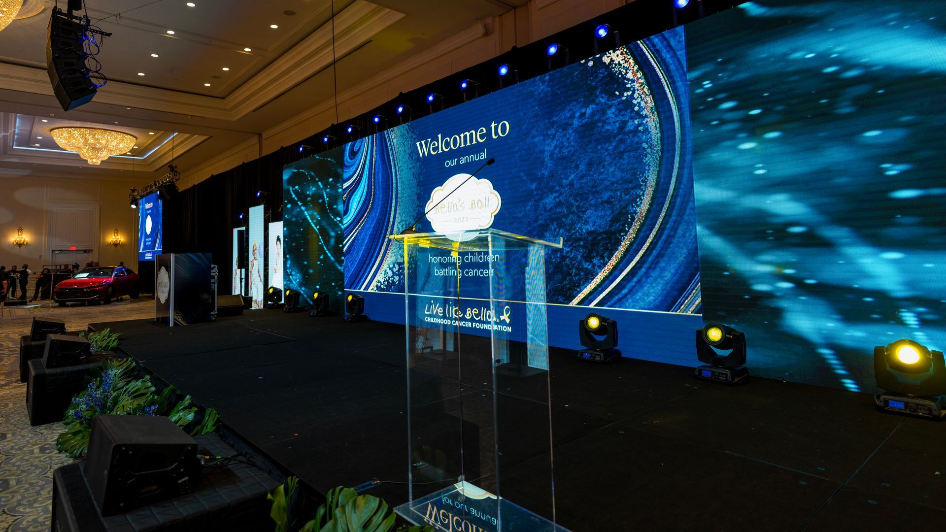 Conference stage with a large blue LED backdrop and podium in a banquet hall