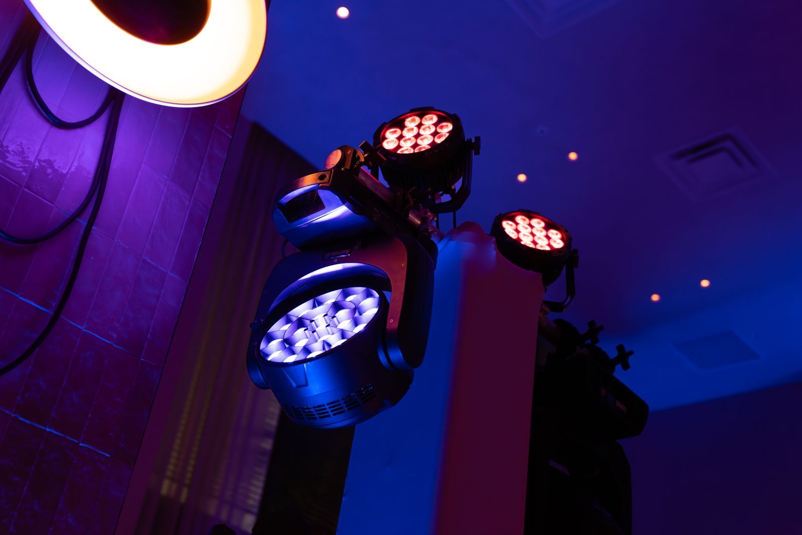 Stage lights glowing blue and pink in a dark indoor venue