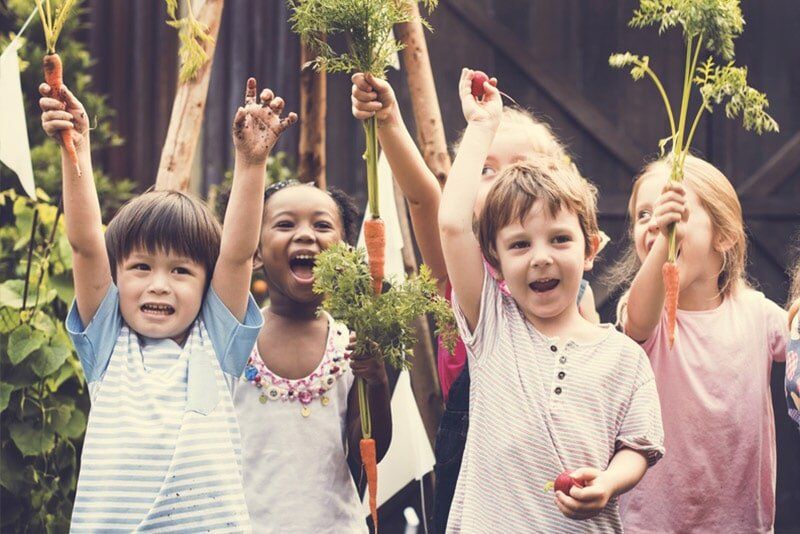 Kids Holding Vegetables — Child Care in Bowen, QLD