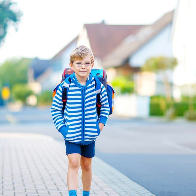Boy walking with backpack — Child Care in Bowen, QLD