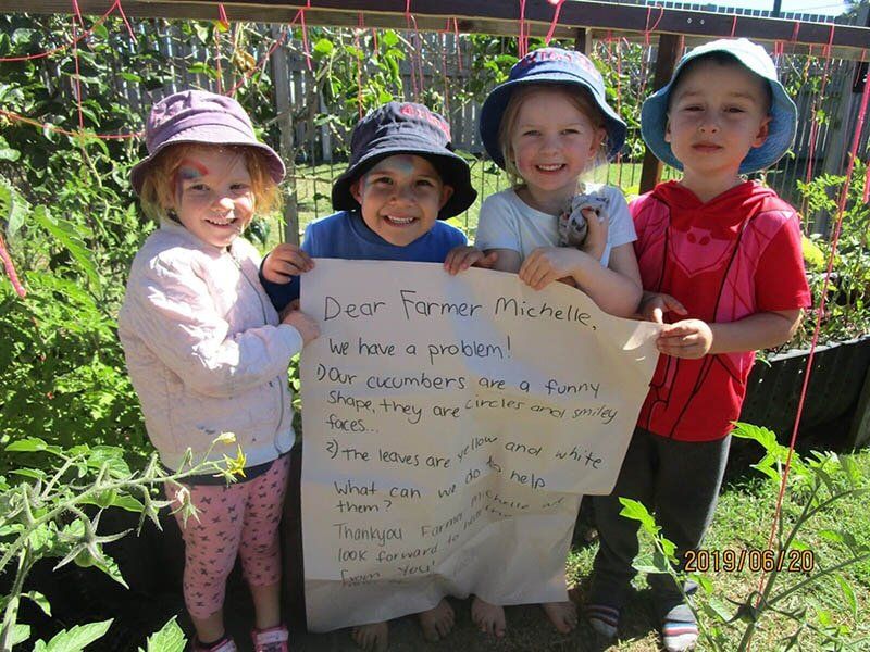 Kids Holding Letter — Child Care in Bowen, QLD
