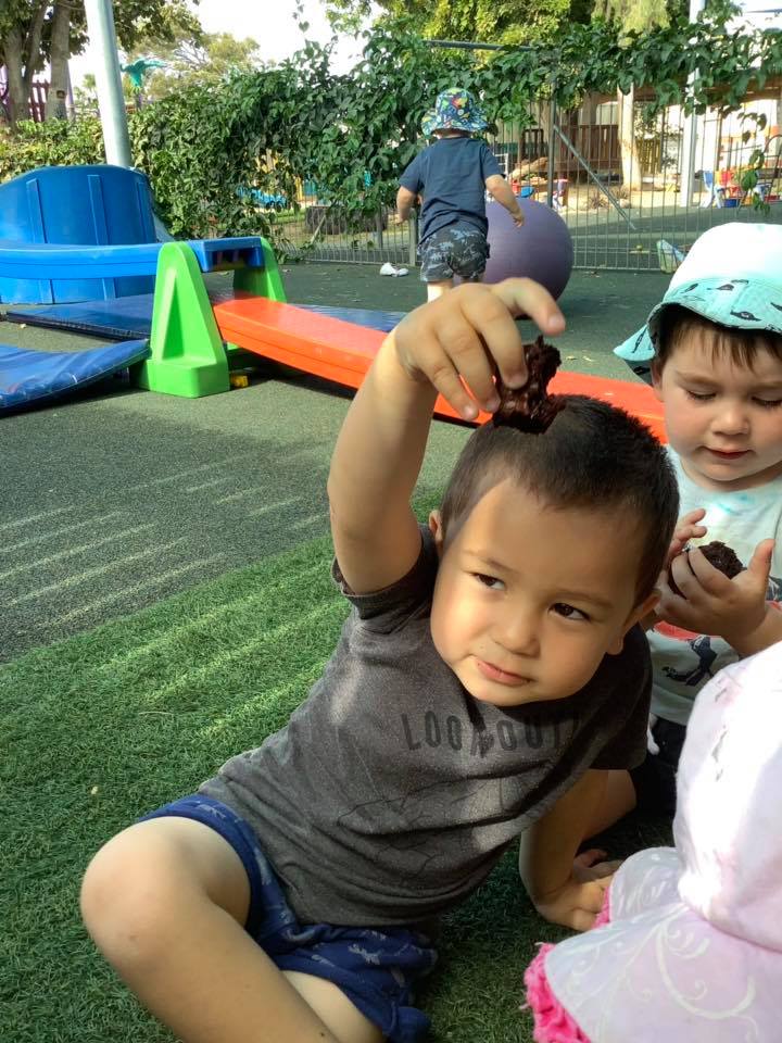 Boy Holding Brownie — Child Care in Bowen, QLD