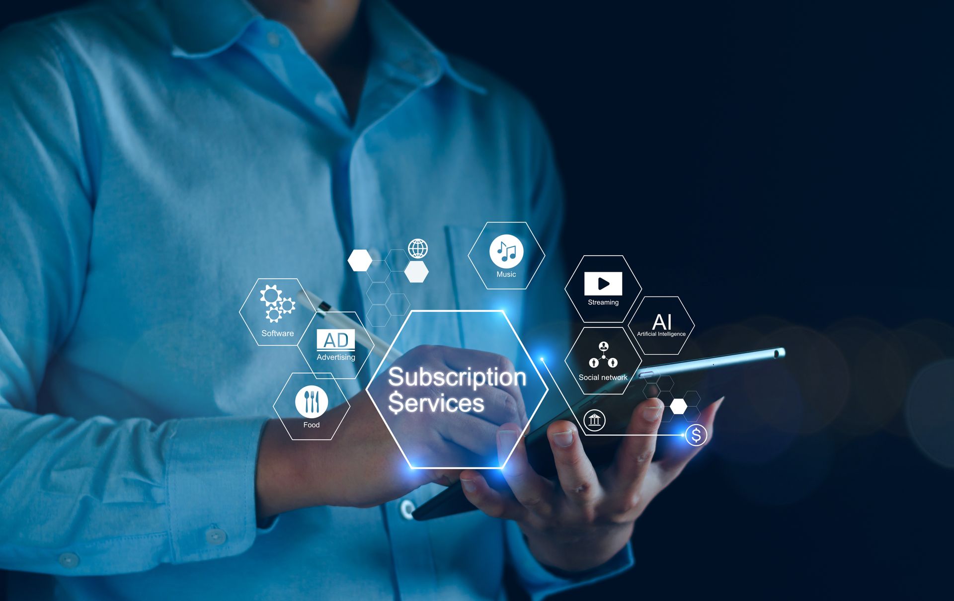 A man in a blue shirt is holding a cell phone in his hand.