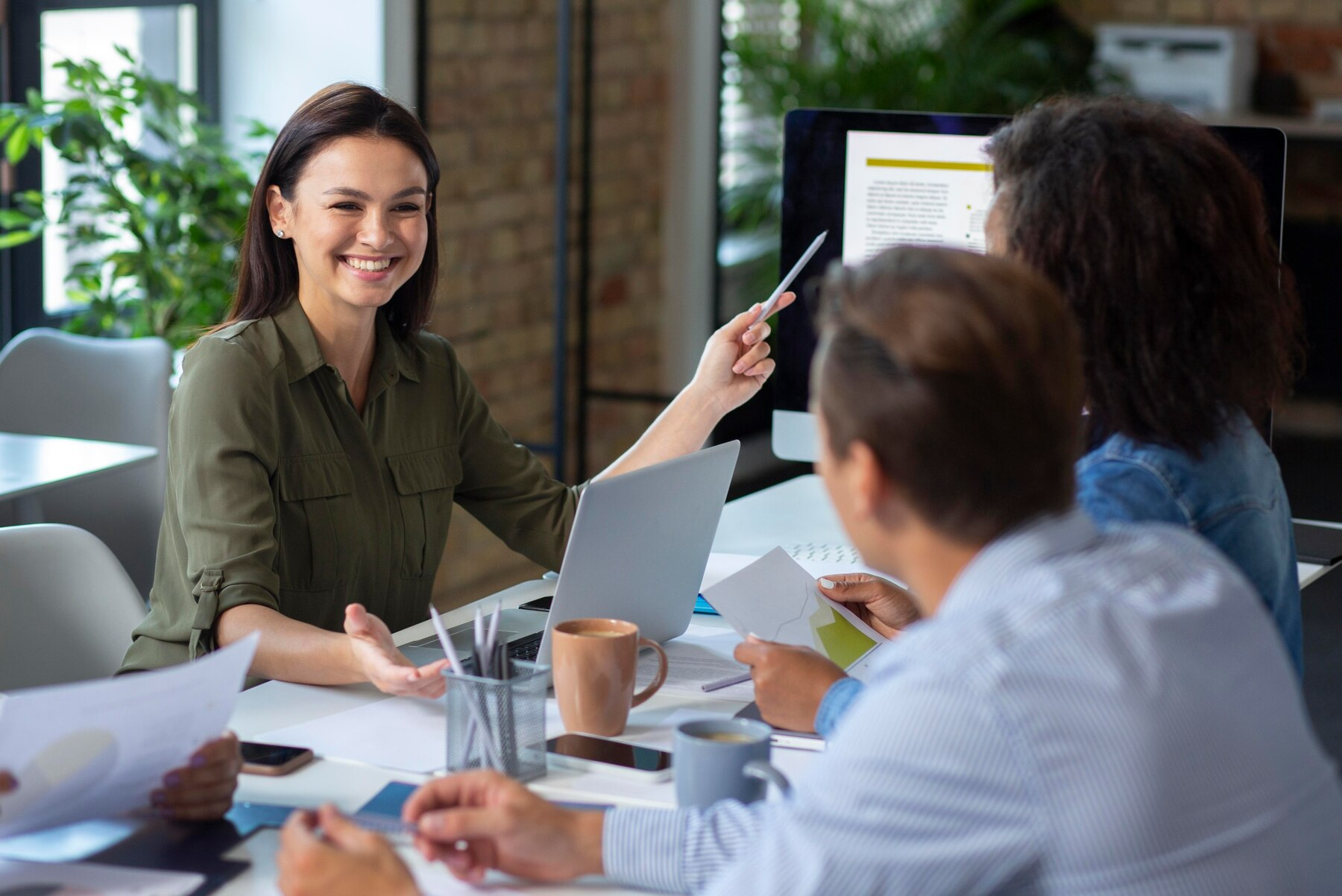 A group of people are sitting around a table having a meeting.