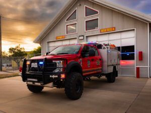 A red fire truck is parked in front of a fire station.