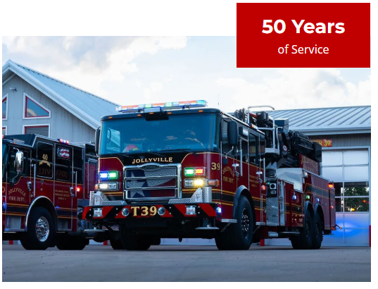 Two fire trucks are parked in front of a building that says 50 years of service