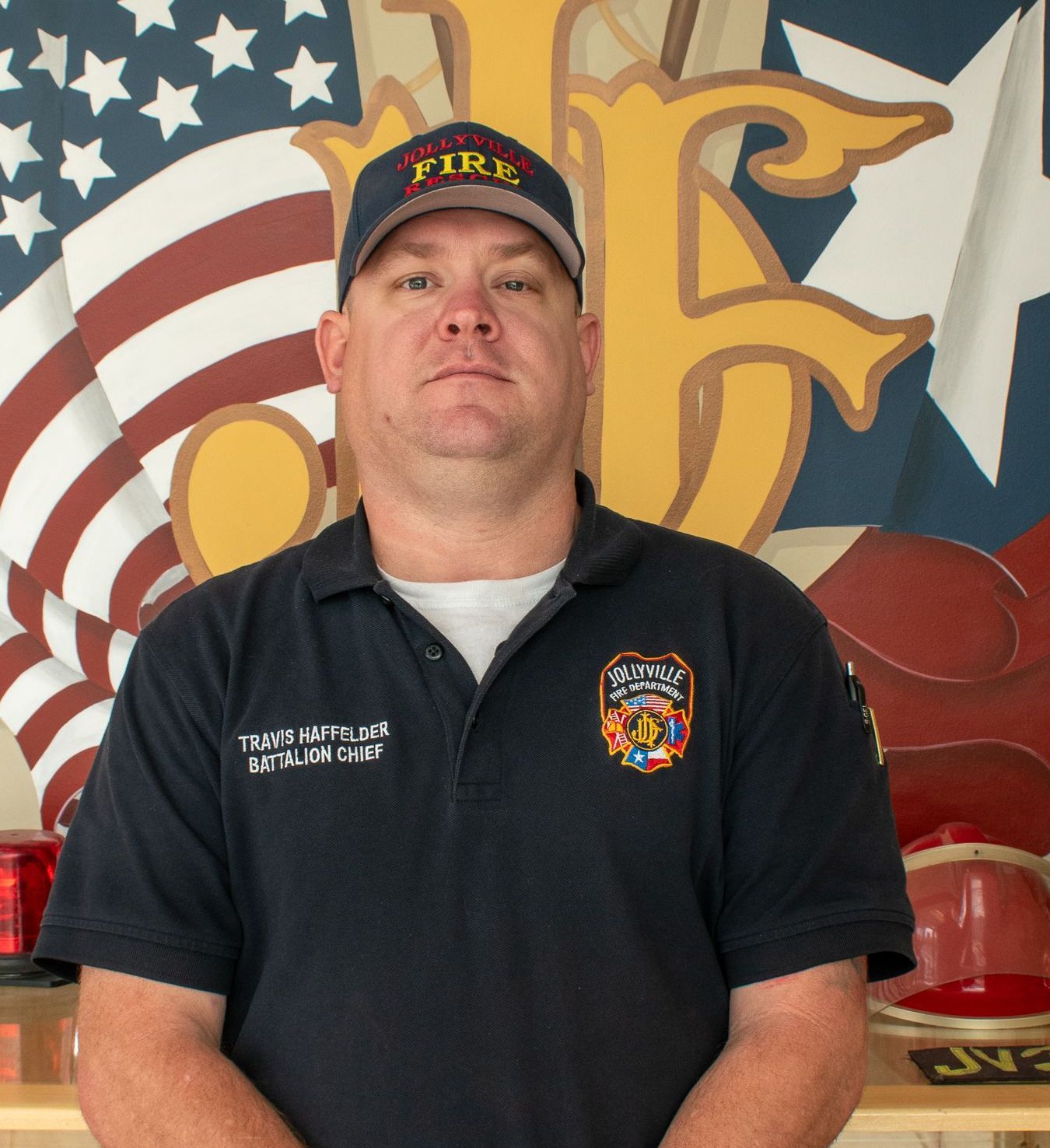 A man in a fireman 's uniform is standing in front of a stone wall