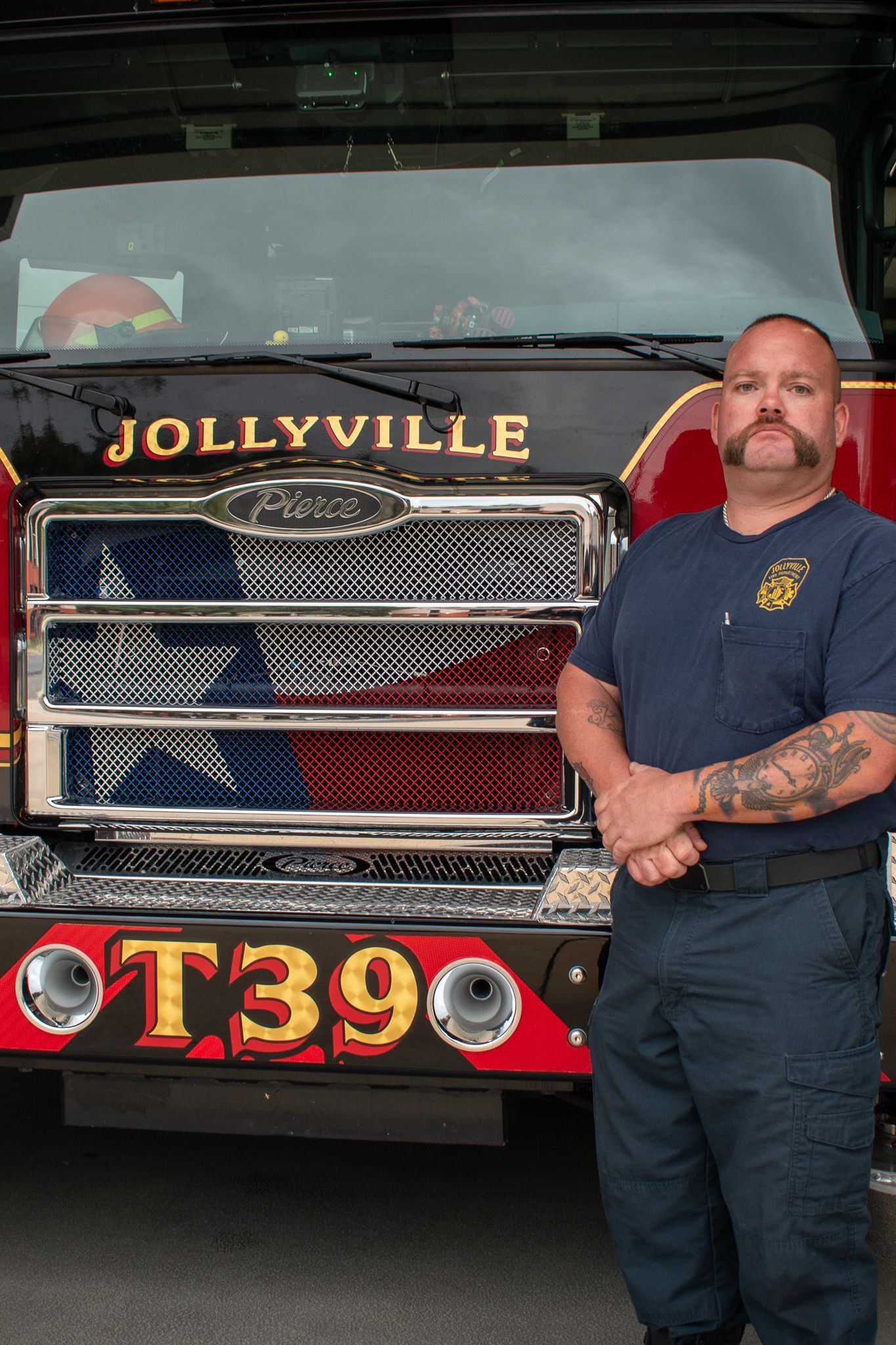 A firefighter is standing in front of a fire engine.