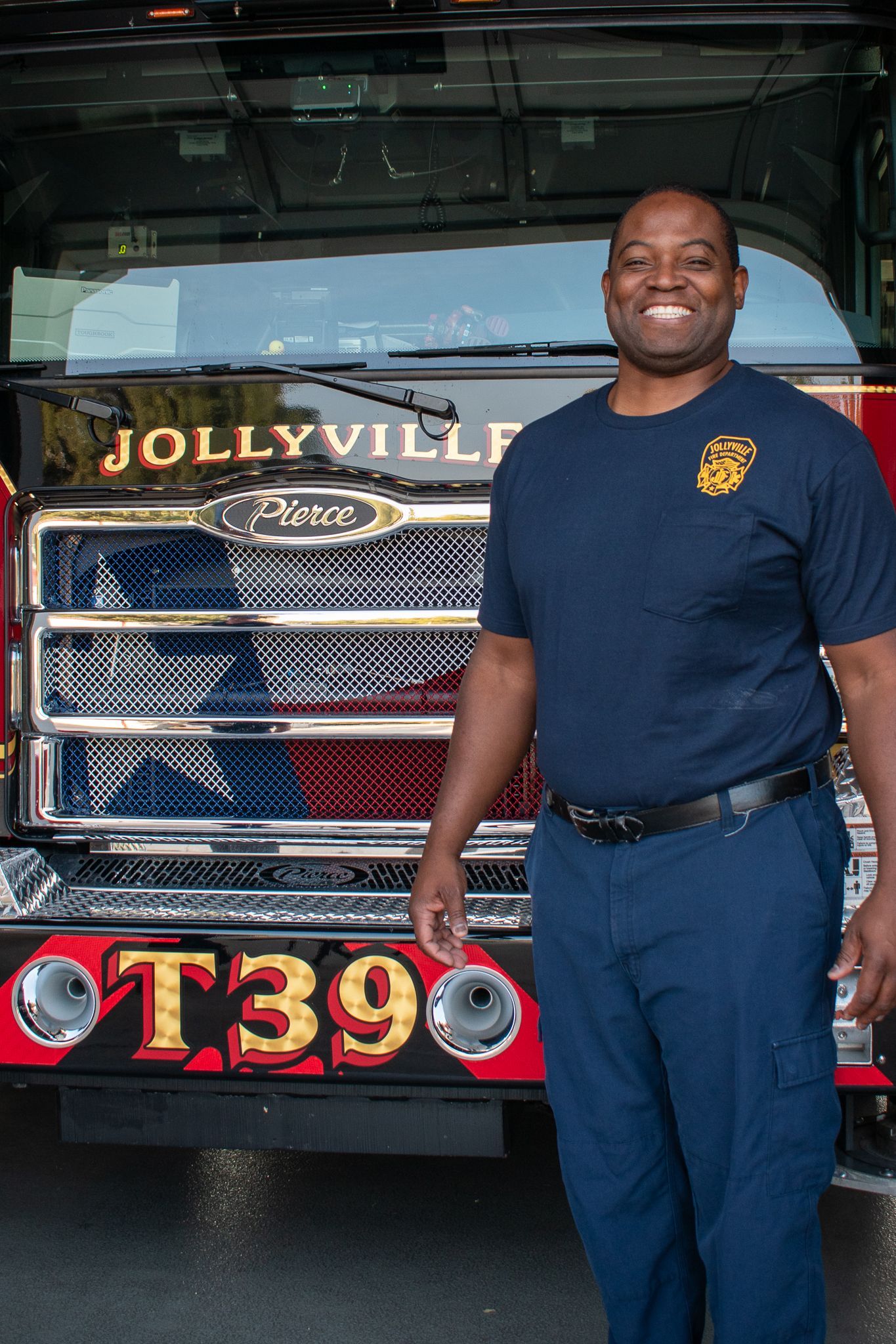 A firefighter is standing in front of a fire engine.