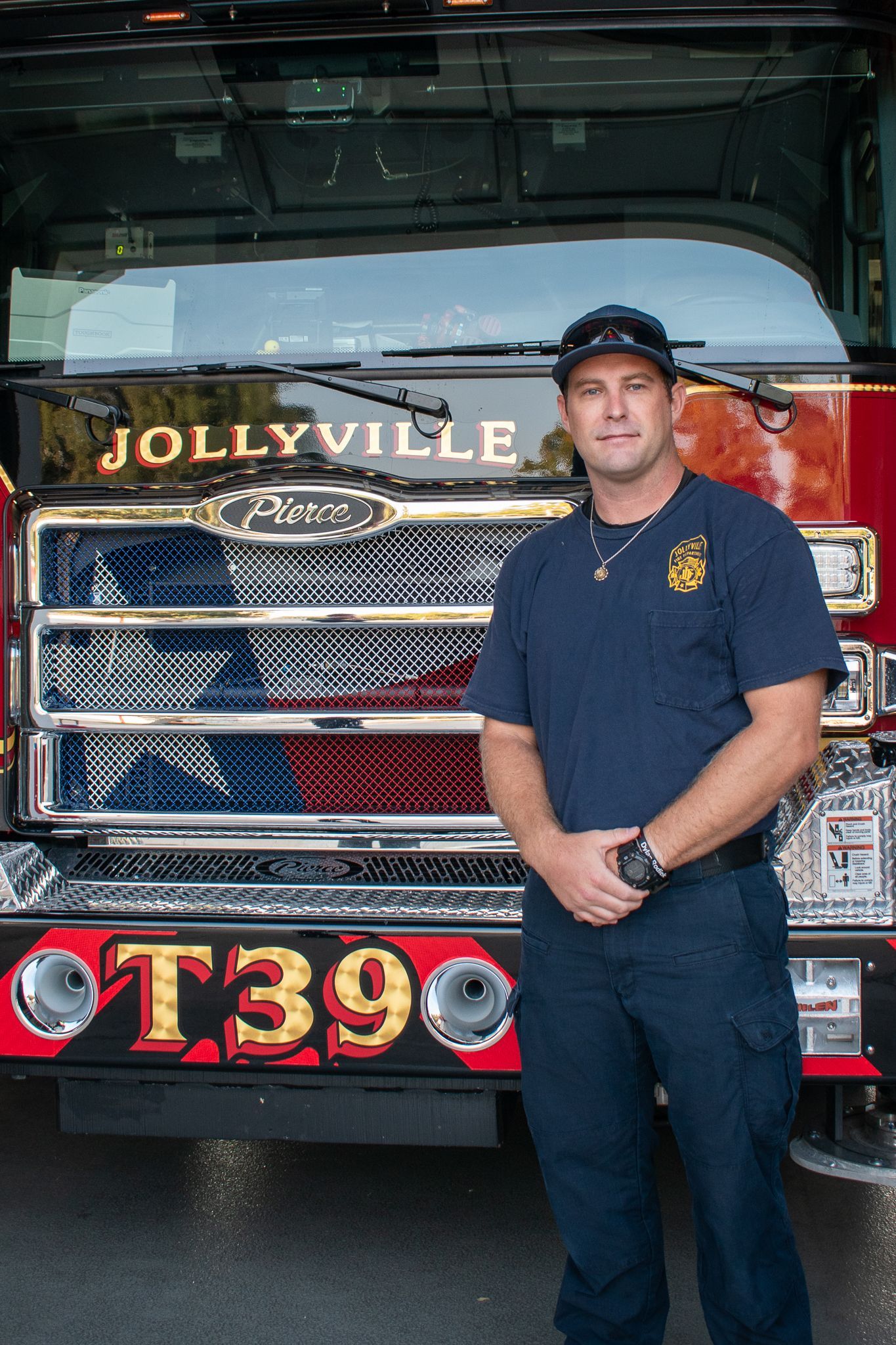 A firefighter is standing in front of a fire engine.