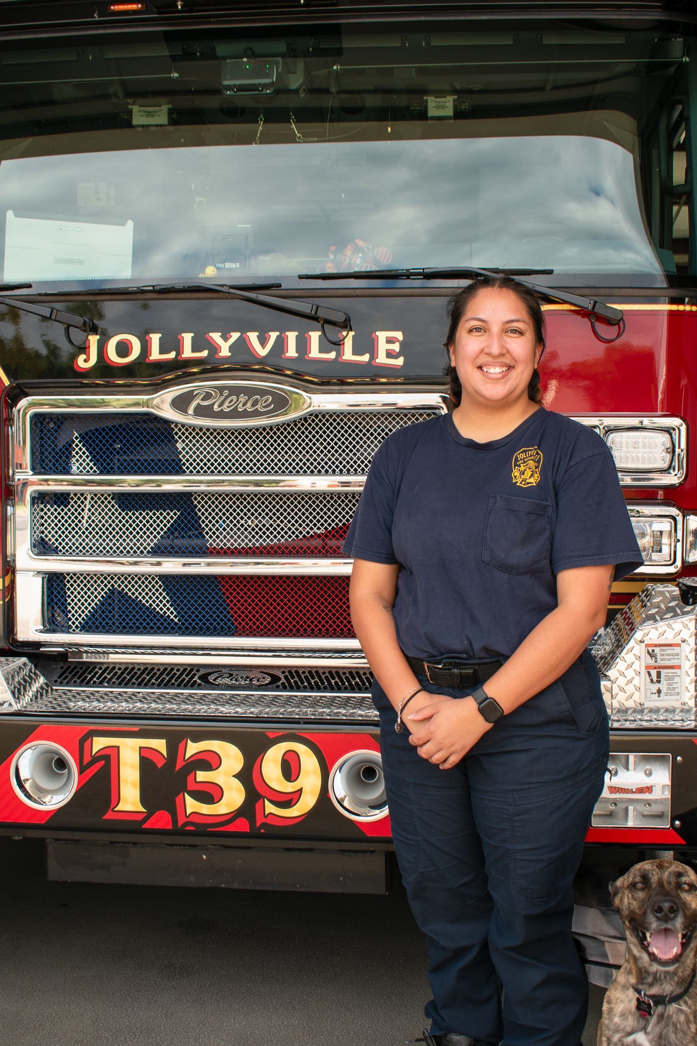 A firefighter  is standing in front of a fire engine.