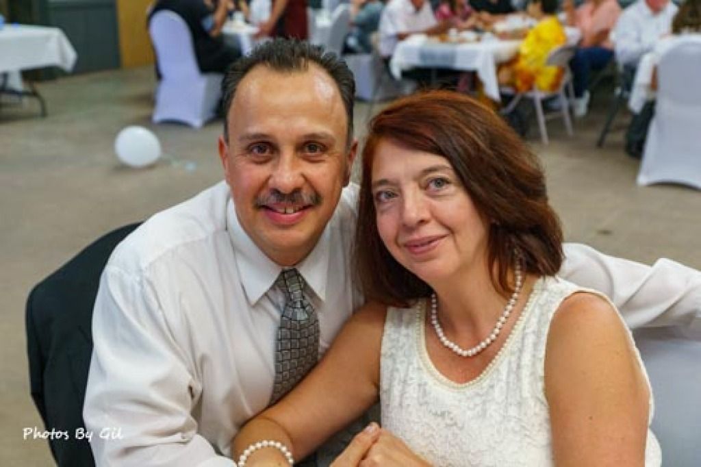 A smiling couple sits closely at a formal event. 