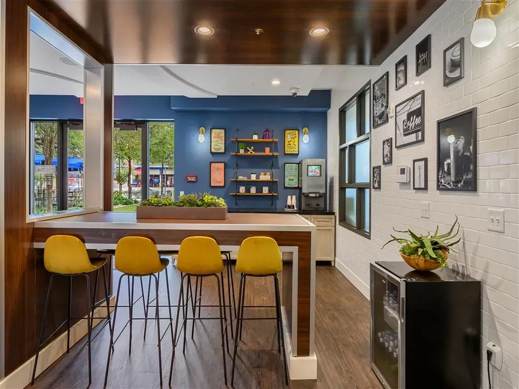 Modern resident lounge area with a coffee bar and seating.