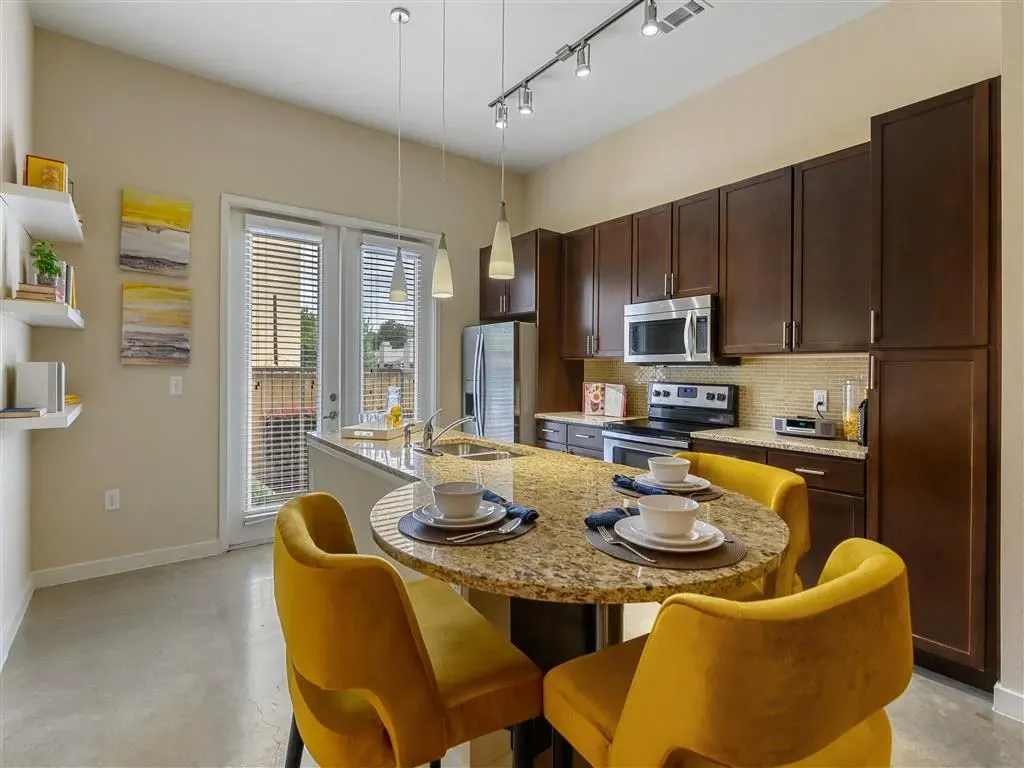 Modern kitchen with dark wood cabinets, stainless steel appliances, and island with seating.
