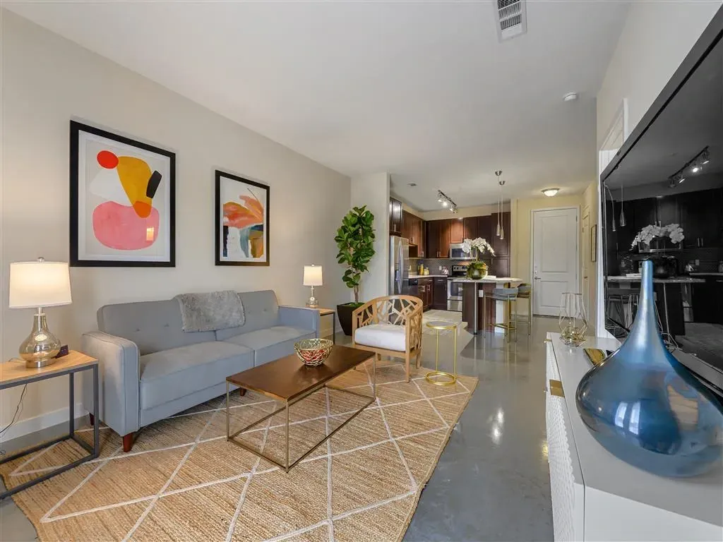 Modern living room and kitchen with contemporary furniture and decor.