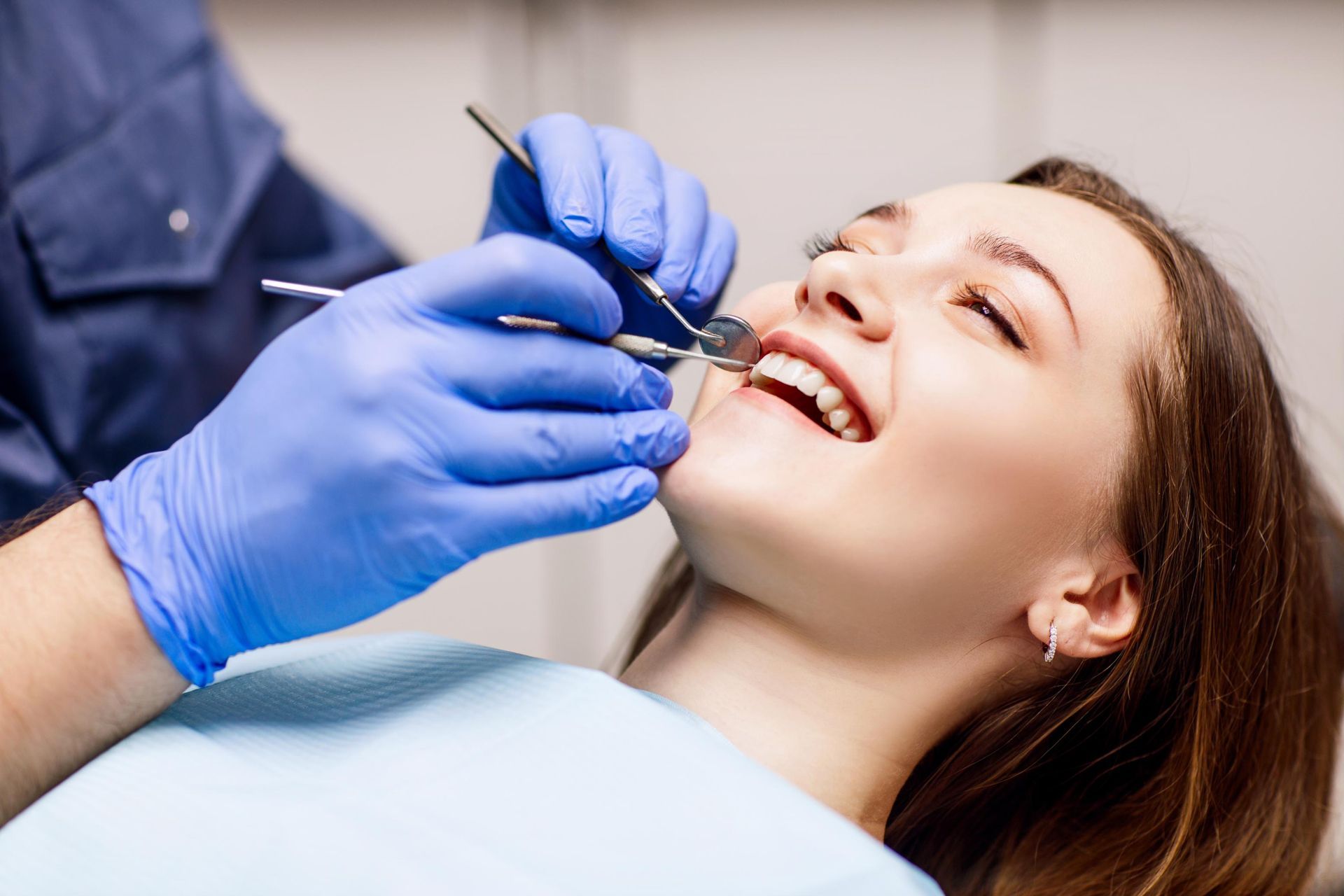 A woman is having her teeth examined by a dentist.