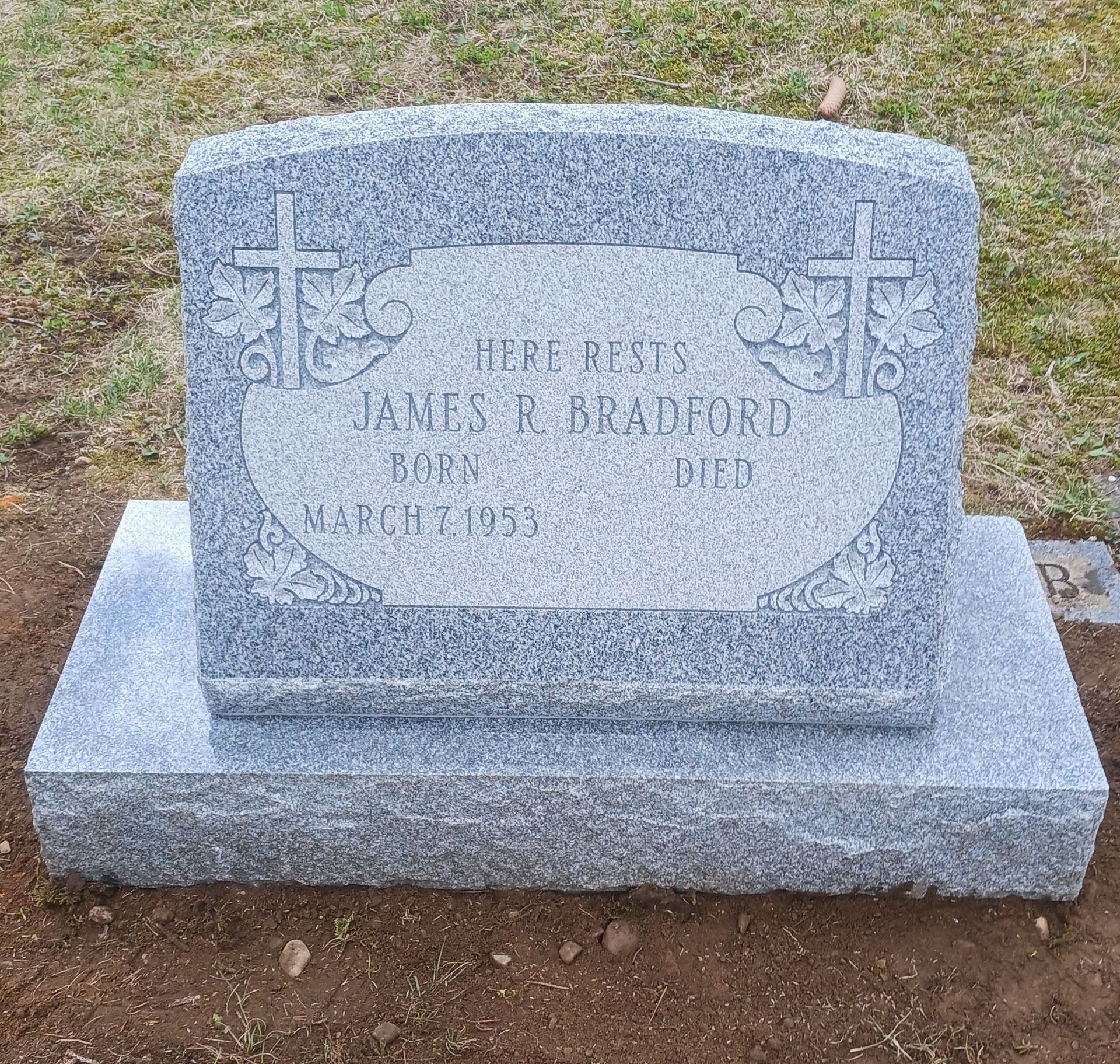 Gray granite tombstone with cross carvings, engraved with