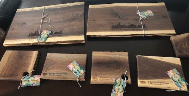 Wooden boards with small colorful tied tags arranged on a dark surface