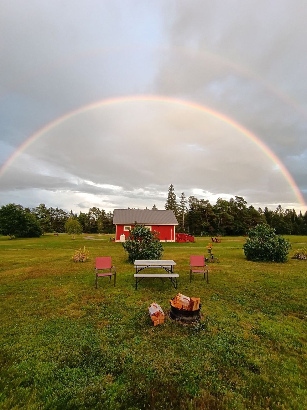 Exterior view of one of the Burke cottages with picnic table and Vermont tree line