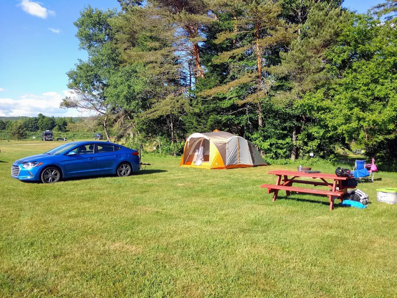 Vermont campsite with picnic table and stone fire pit in morning light