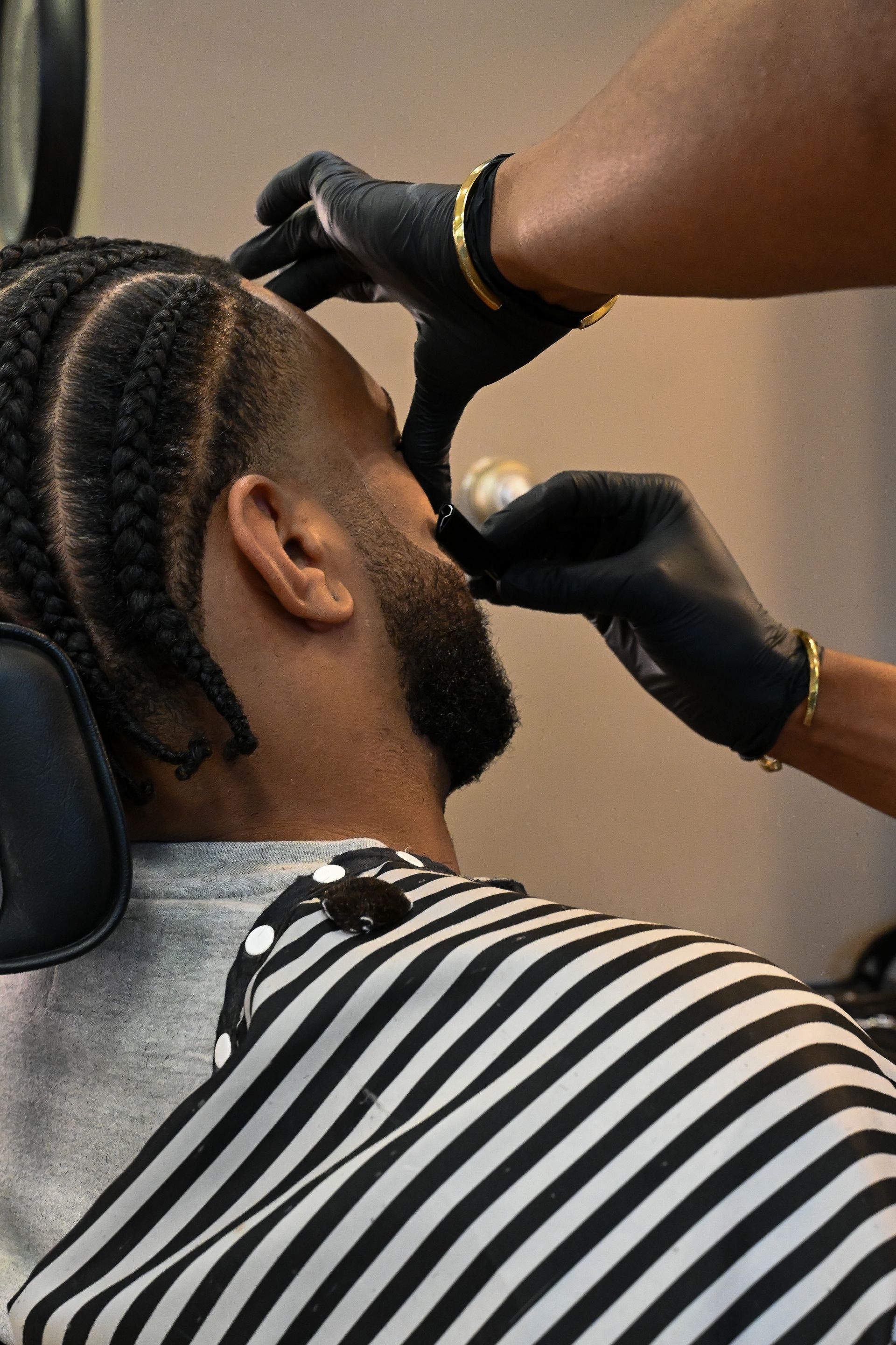 A man is getting his hair cut at a barber shop.